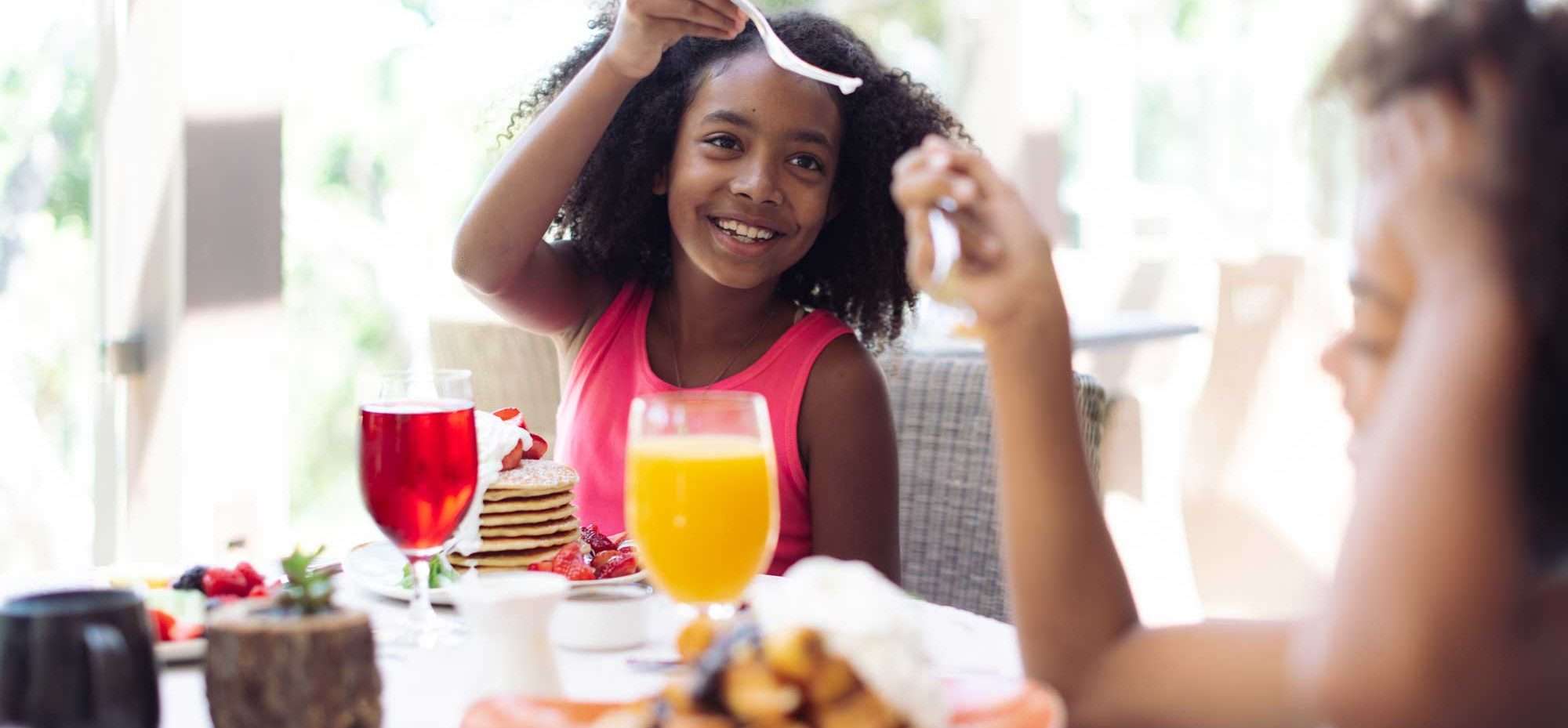 Girl eating breakfast at table