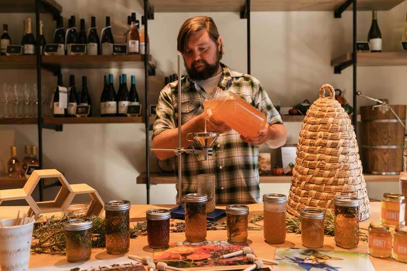 Person filling honey glasses