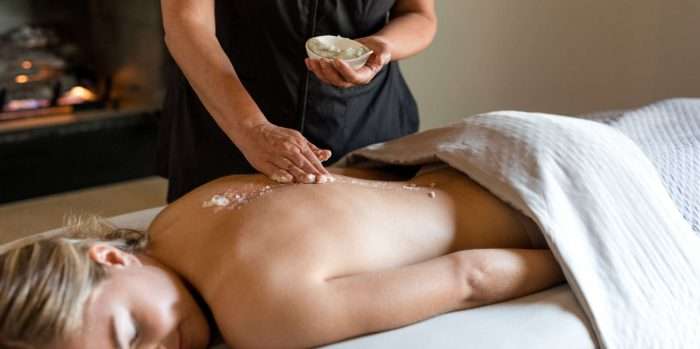 closeup of a woman's back receiving a salt spa treatment at Spa Aiyana